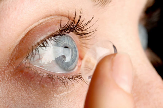Une femme essaie de porter des lentilles de contact