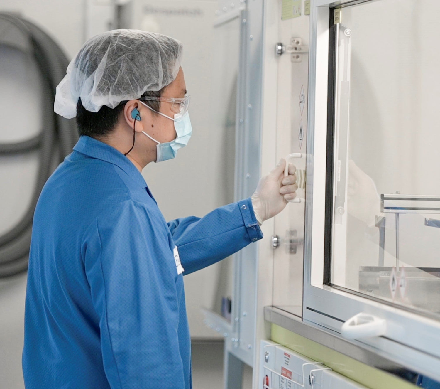 La photo d'un employé de laboratoire essayant d'ouvrir une porte dans le laboratoire. où sont fabriqués les verres