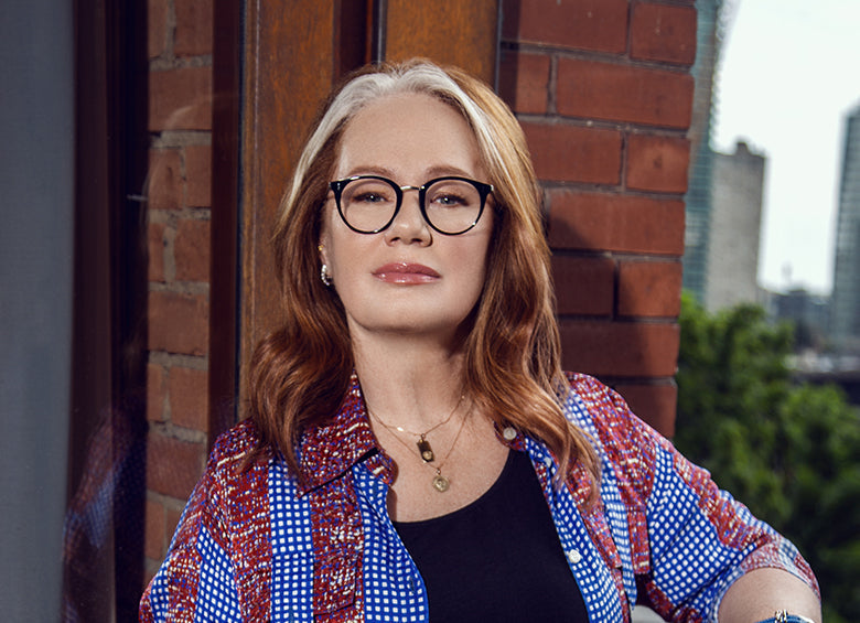 Arlene Dickinson s'asseyant et enfilant la monture de lunettes haut de gamme Sacori associée à des lentilles de haute qualité fabriquées au Canada.