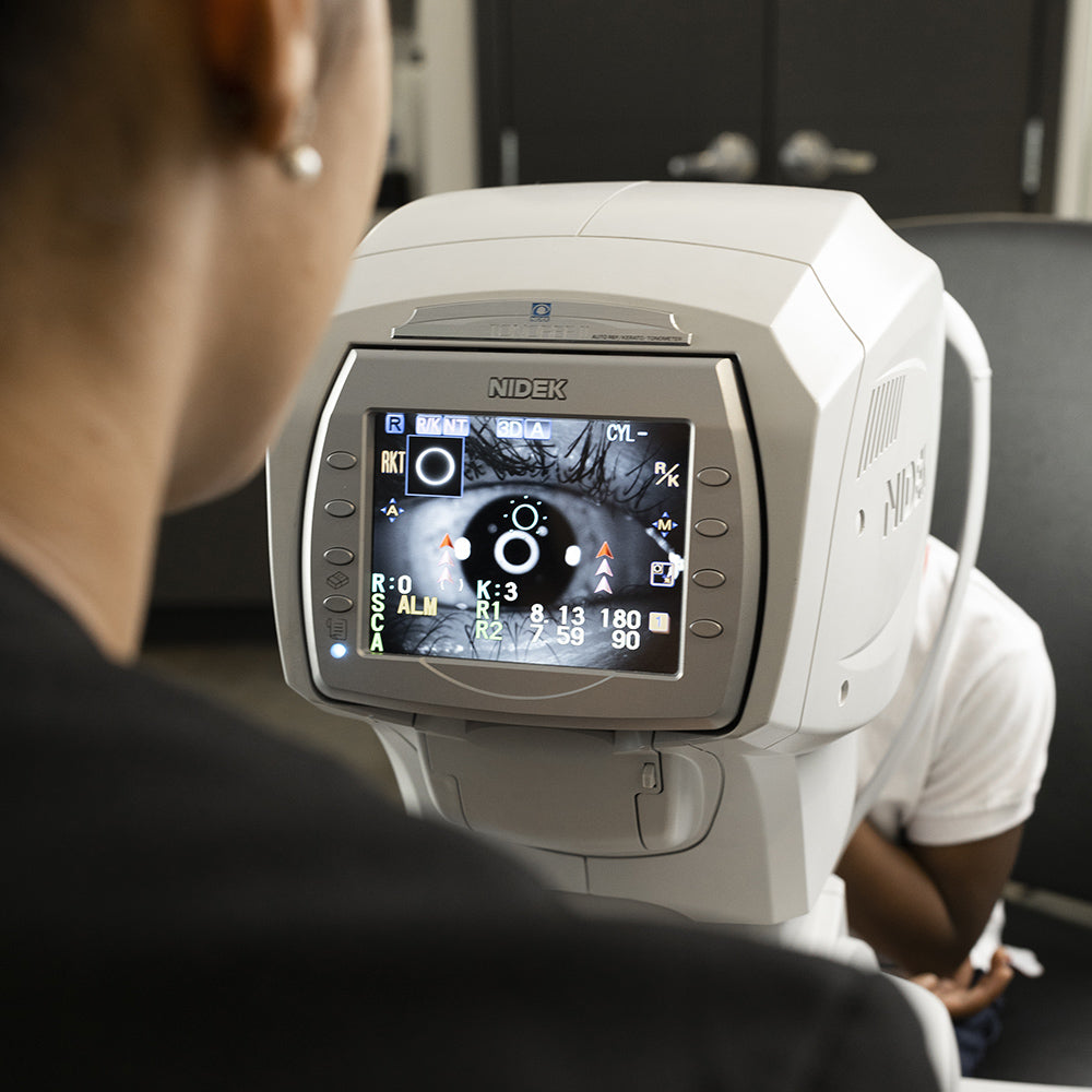 Un optométriste effectuant un examen de la vue sur l'œil d'un patient à l'aide de la technologie oculaire