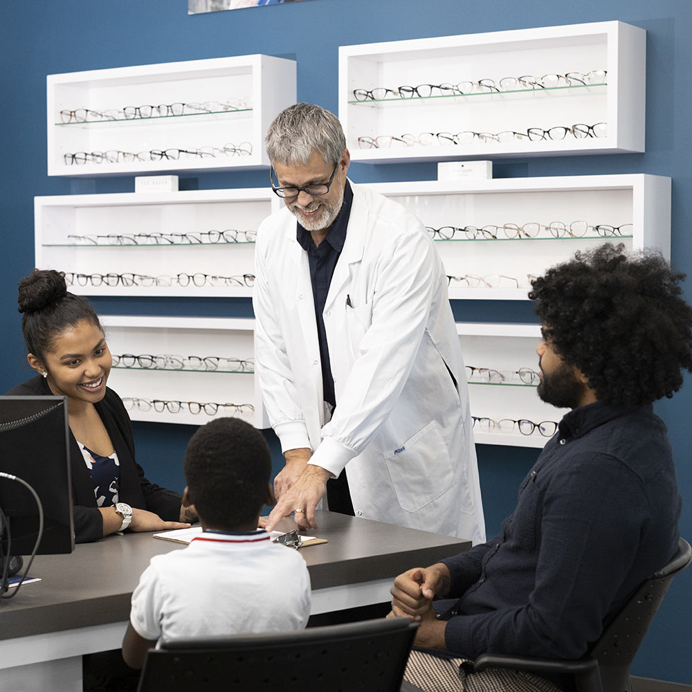 Un optométriste s'occupe avec joie d'une famille qui a besoin de services de soins oculaires