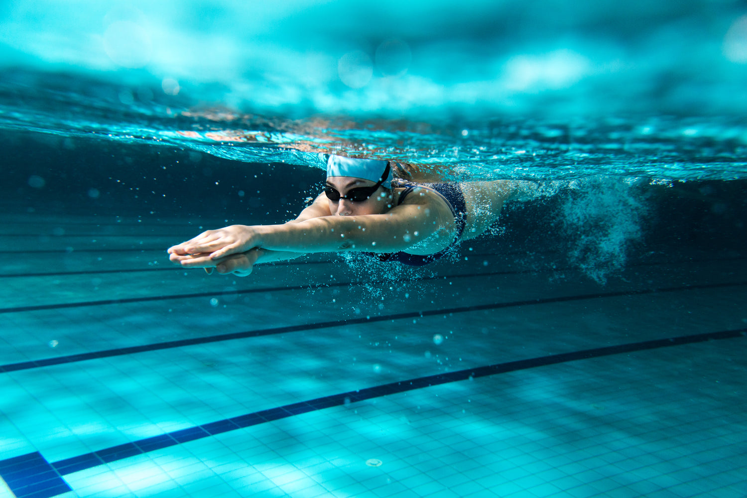 A lady swimmer with her dark swimming glasses under the water
