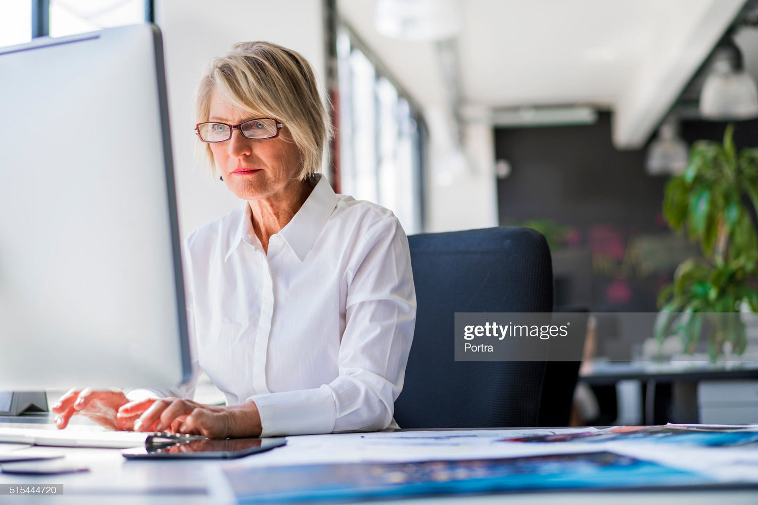 Une dame assise devant un ordinateur met en place des lentilles spécialisées dans l'espace iD conçues pour le travail